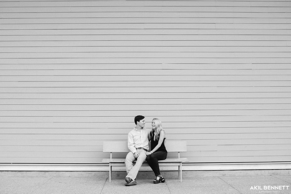 Black-and-white engagement portrait against the Menil siding