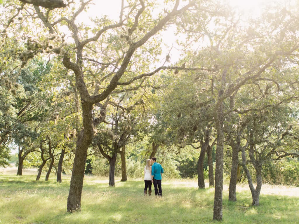 Couple under oaks in fall, Texas engagement session