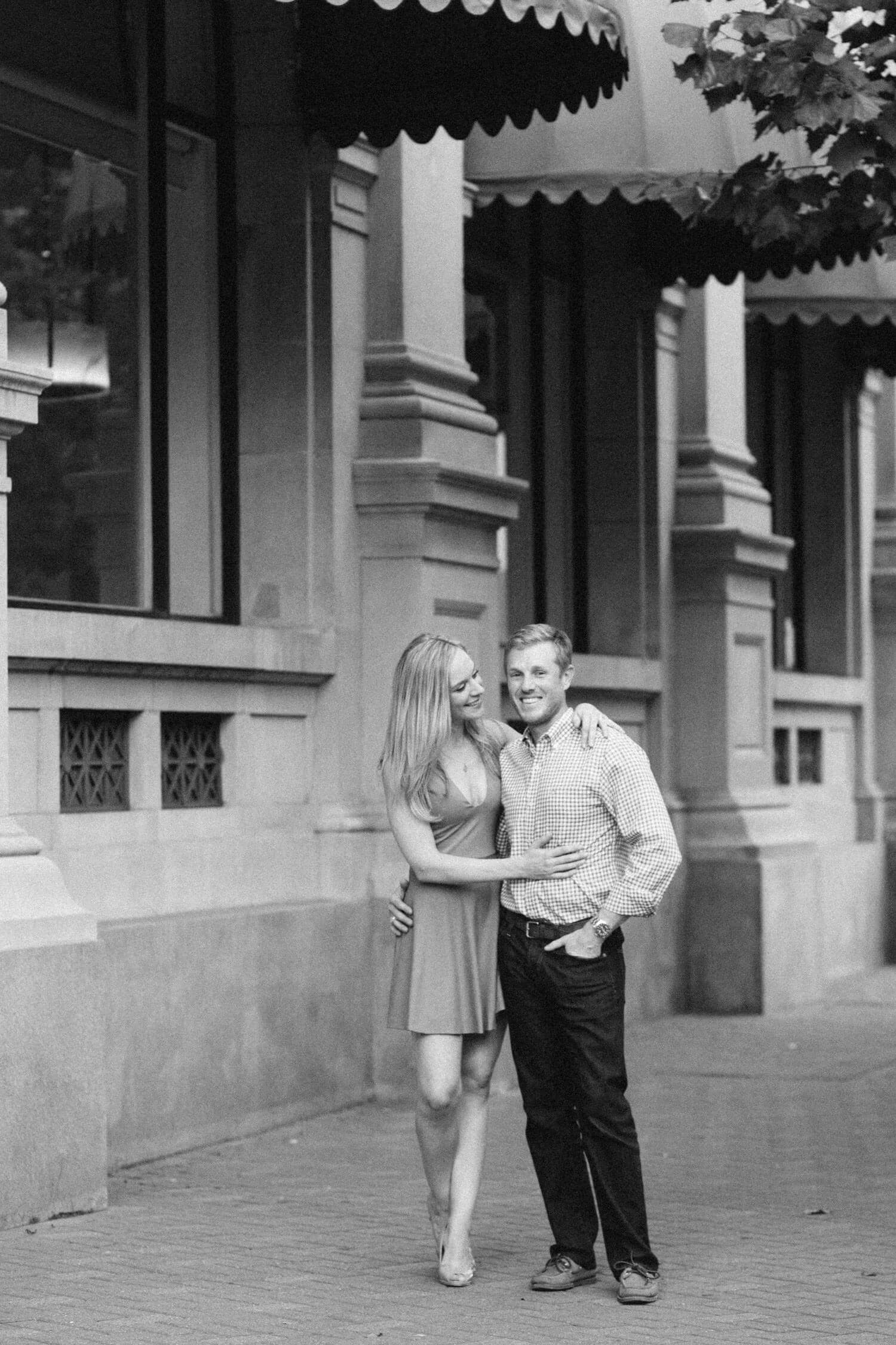 Engaged Houston couple taking photos in Market Square