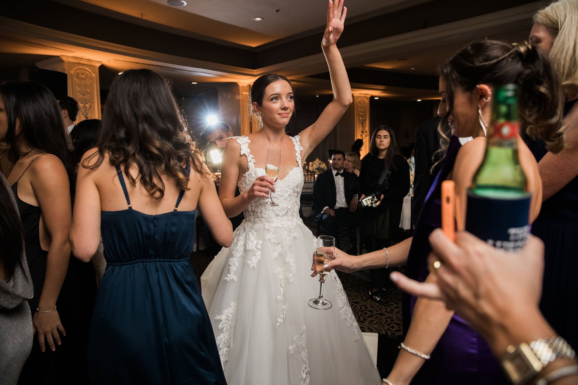 Sydney dancing with friends in deep teal dresses at the reception.