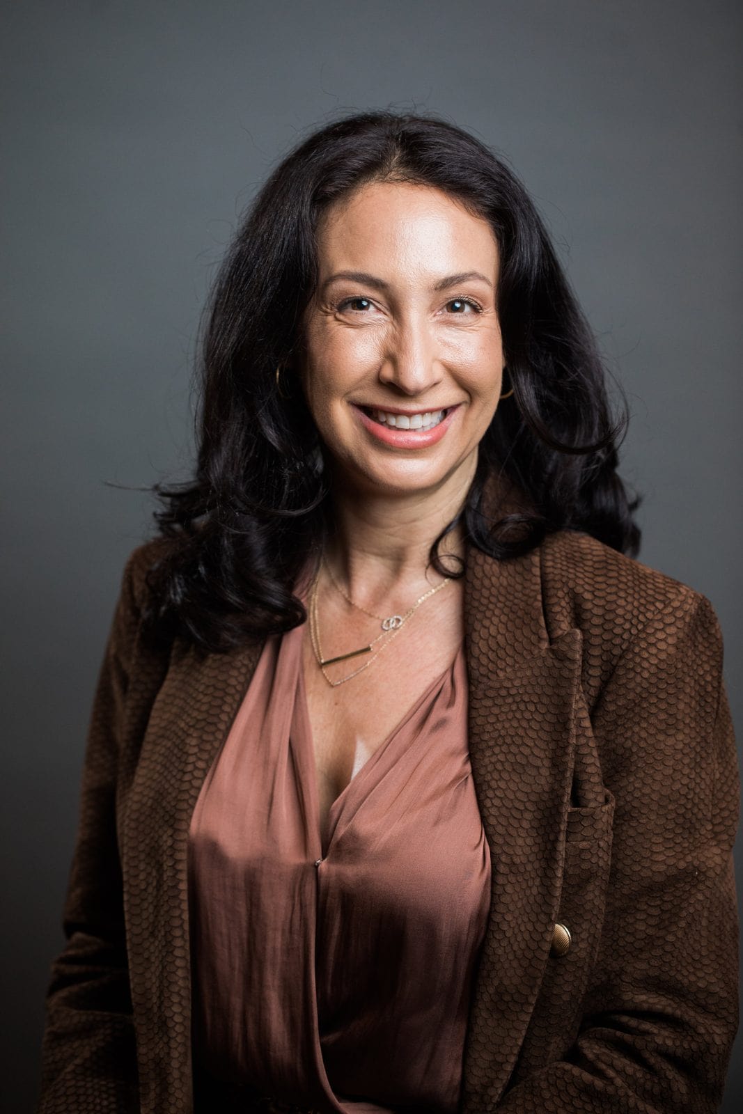 Houston headshot photographer: smiling woman in a brown jacket