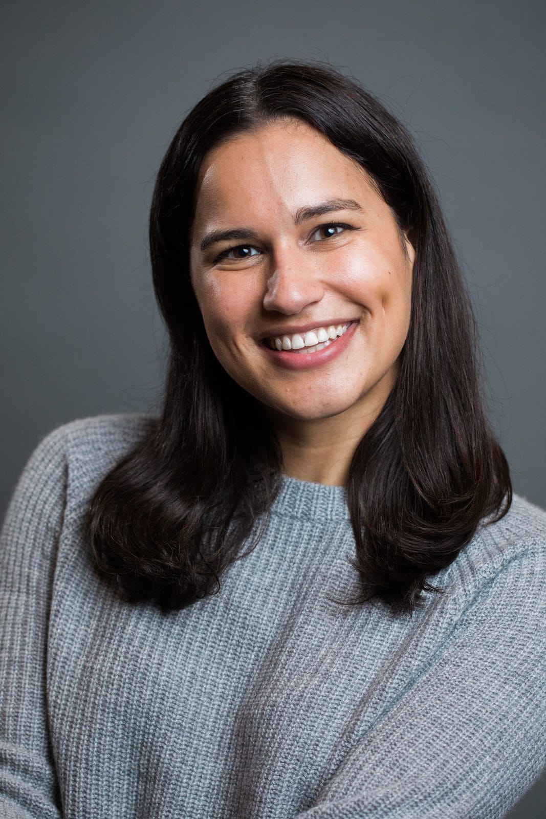 On-location headshots Houston: smiling woman in a gray sweater