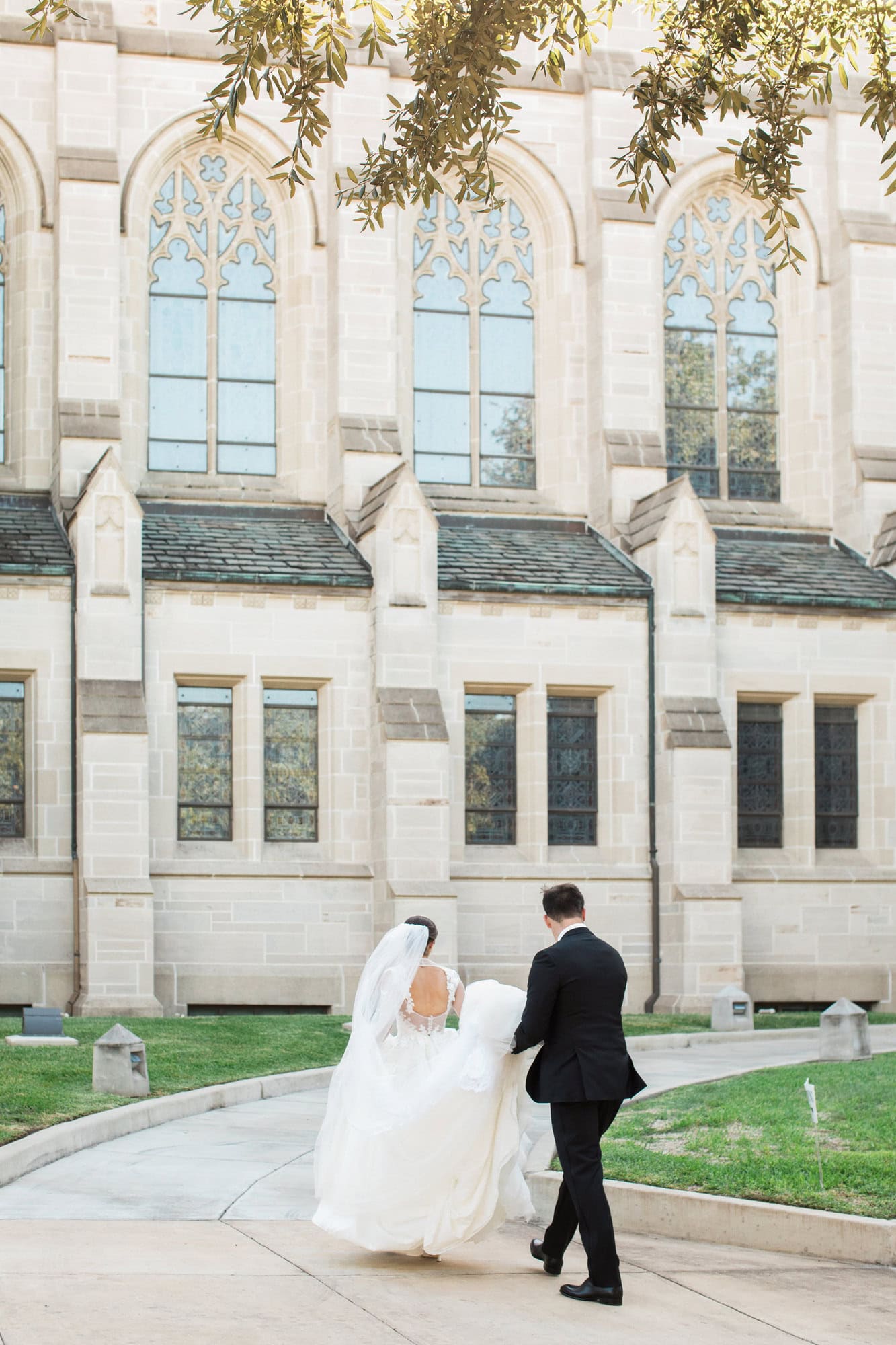 Sydney and Cade walking beside the stone exterior of St. Paul’s.